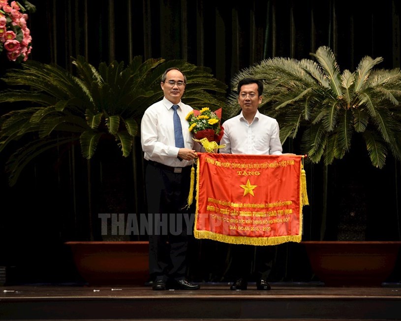 B&iacute; thư Th&agrave;nh ủy TPHCM Nguyễn Thiện Nh&acirc;n trao Cờ thi đua cho Nh&acirc;n d&acirc;n v&agrave; c&aacute;n bộ x&atilde; B&igrave;nh Lợi, huyện B&igrave;nh Ch&aacute;nh. (ảnh: Đan Như)