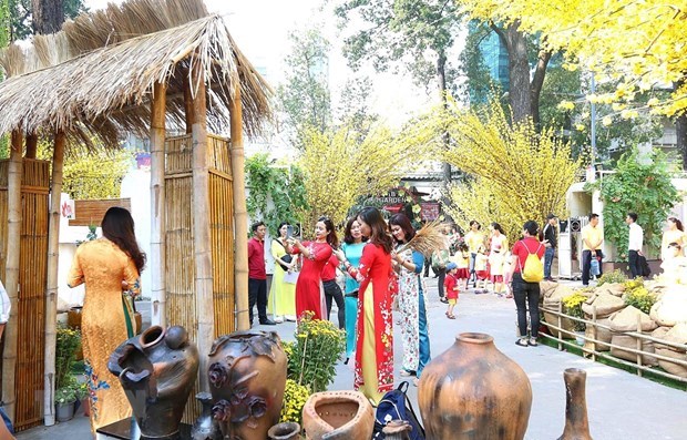 Các bạn trẻ chụp ảnh tại Lễ hội Tết Việt với nét mộc mạc của làng quê, hay một góc Sài Gòn xưa. Ảnh minh họa. (Ảnh: Thanh Vũ /TTXVN)