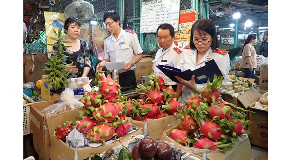 Ban Quản lý an toàn thực phẩm TP kiểm tra nguồn gốc xuất xứ trái cây nhập vào chợ. Ảnh: HOÀNG HÙNG