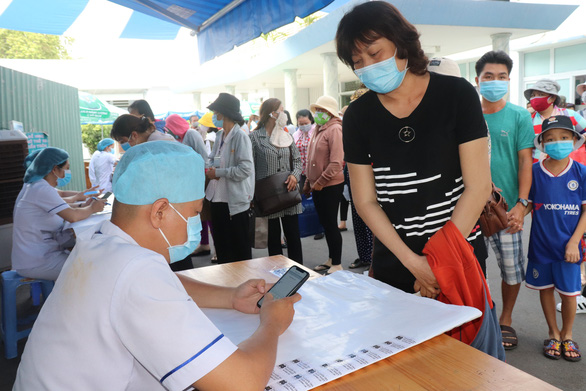 Nhân viên y tế hỗ trợ người bệnh khai báo y tế điện tử tại Bệnh viện Ung bướu TP.HCM (cơ sở 1) - Ảnh: XUÂN MAI