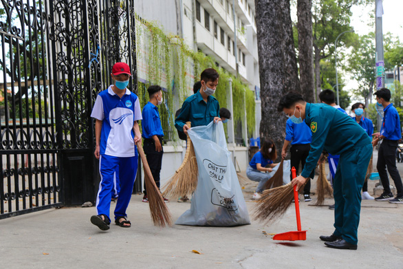 Các bạn sinh viên ĐH Sài Gòn dọn dẹp vệ sinh đường phố vào sáng 28-2, khởi động Tháng thanh niên 2021 - Ảnh: Đoàn Trường ĐH Sài Gòn