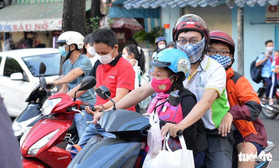 Học sinh Trường tiểu học Nguyễn Văn Trỗi, quận 4, TP.HCM được phụ huynh đưa đến trường sáng 1-3 - Ảnh: TỰ TRUNG