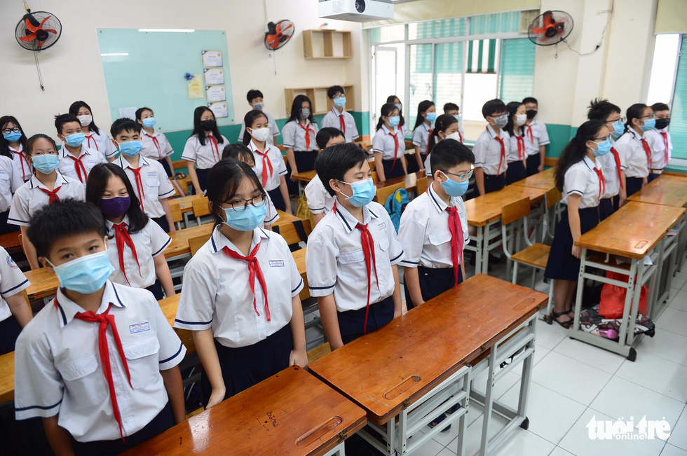 Để tránh tập trung, Trường THCS Nguyễn Du cho học sinh chào cờ tại lớp học - Ảnh: QUANG ĐỊNH