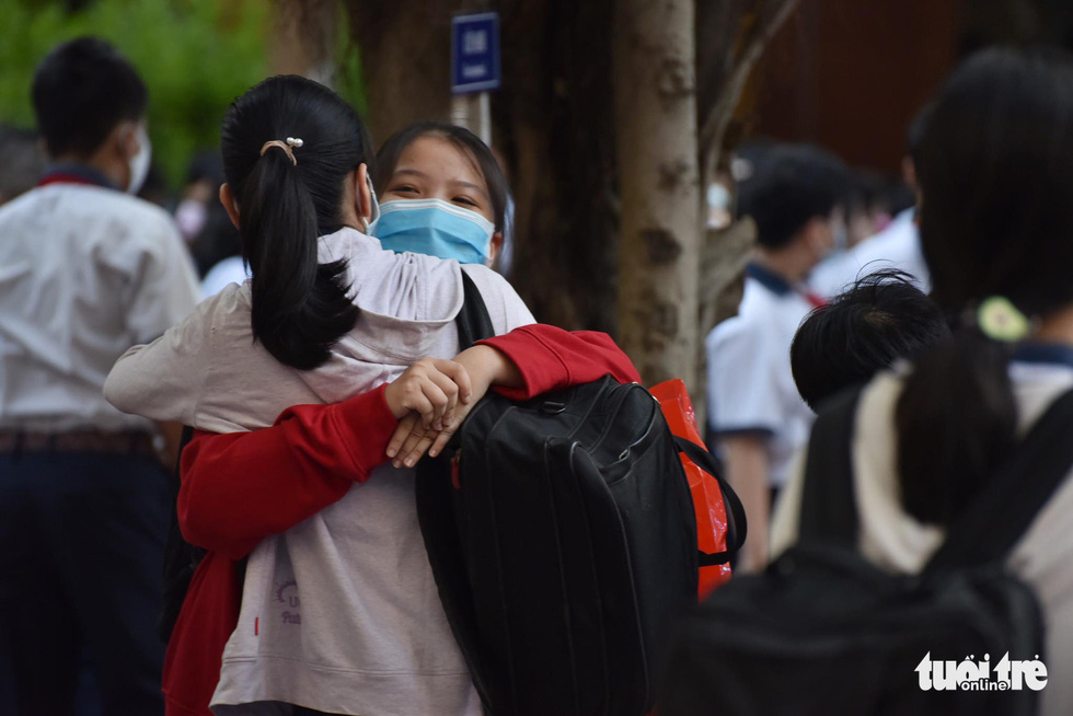 Các em học sinh Trường THCS Lê Văn Tám (Q.Bình Thạnh) vui mừng ôm chầm lấy nhau khi trở lại trường sáng 1-3 - Ảnh: NGỌC PHƯỢNG