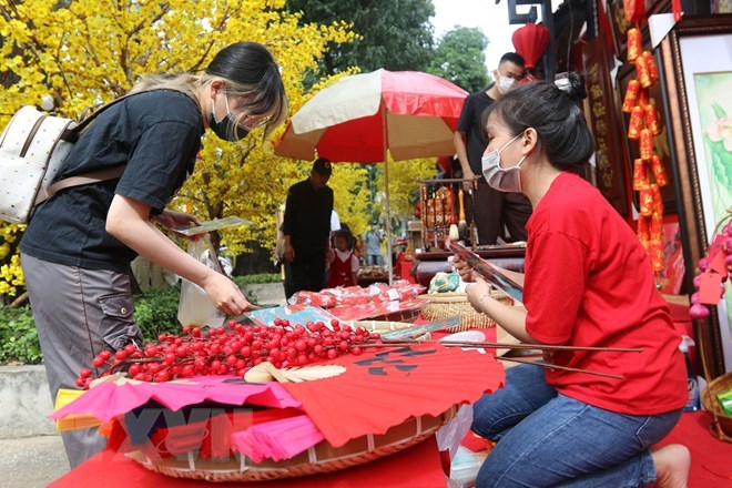 Kh&aacute;ch tham quan mua sắm qu&agrave; lưu niệm tại Phố &ocirc;ng đồ - Lễ hội Tết Việt Qu&yacute; M&atilde;o năm 2023 tại Nh&agrave; văn h&oacute;a Thanh ni&ecirc;n Th&agrave;nh phố Hồ Ch&iacute; Minh. (Ảnh: Thanh Vũ/TTXVN)