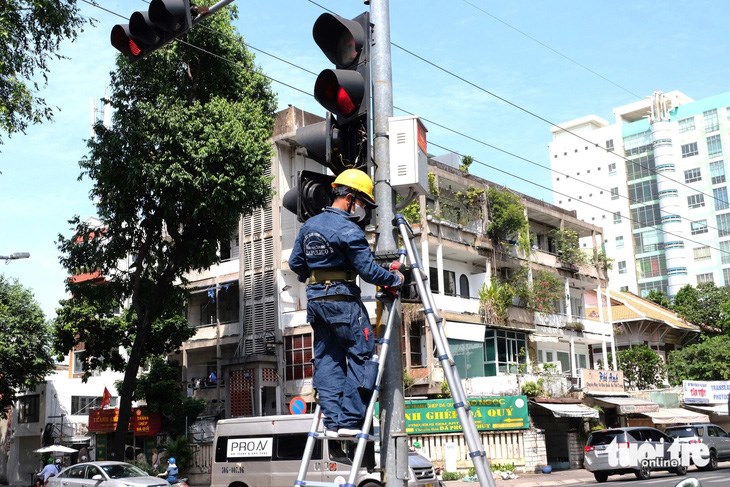 Đơn vị thi c&ocirc;ng lắp đ&egrave;n rẽ phải khi đ&egrave;n đỏ tại giao lộ ở TP.HCM - Ảnh: PHƯƠNG NHI