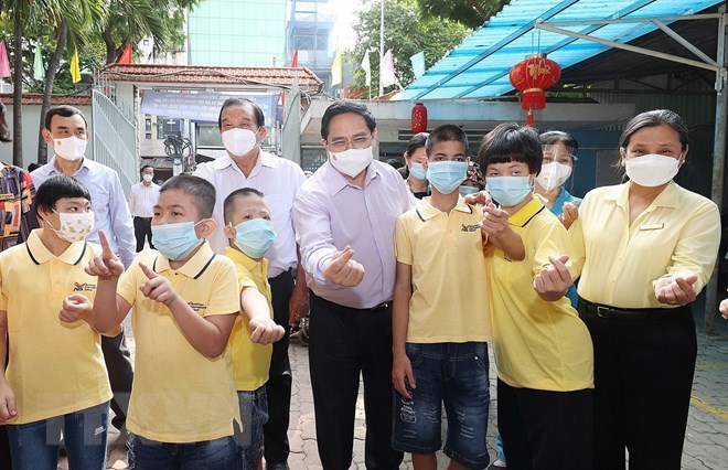 Thủ tướng Phạm Minh Ch&iacute;nh thăm trẻ em đang được chăm s&oacute;c tại Trung t&acirc;m bảo trợ trẻ t&agrave;n tật mồ c&ocirc;i Thị Ngh&egrave;. (Ảnh: Dương Giang/TTXVN)