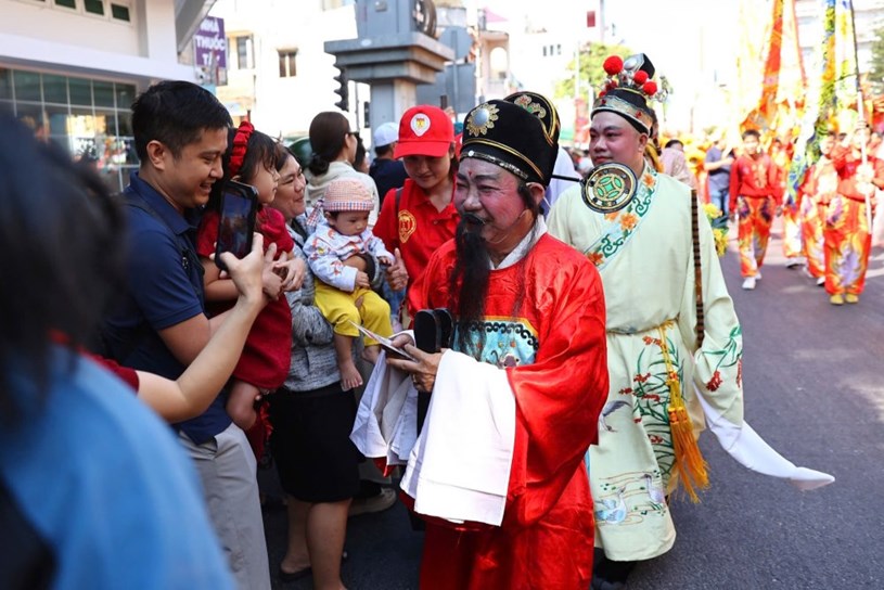 Đ&ocirc;ng người d&acirc;n đứng dọc hai b&ecirc;n đường để ch&agrave;o mừng, cầm theo nhang, chắp tay cầu nguyện khi đo&agrave;n rước tượng Quan C&ocirc;ng đi ngang qua để lấy v&iacute;a may mắn, t&agrave;i lộc đầu năm.