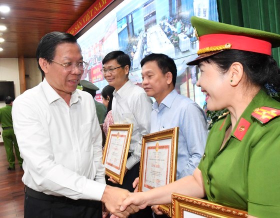 Chủ tịch UBND TPHCM Phan Văn M&atilde;i tặng bằng khen cho c&aacute;c tập thể, c&aacute; nh&acirc;n xuất sắc trong việc triển khai, thực hiện Đề &aacute;n 06. Ảnh: VIỆT DŨNG