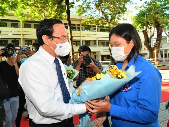 B&iacute; thư Th&agrave;nh ủy TPHCM Nguyễn Văn N&ecirc;n tặng hoa cho nữ t&acirc;n binh. Ảnh: VIỆT DŨNG