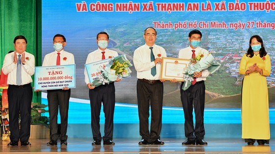 Trưởng đo&agrave;n đại biểu Quốc hội TPHCM Nguyễn Thiện Nh&acirc;n v&agrave; Chủ tịch UBND TPHCM Nguyễn Th&agrave;nh Phong trao bằng c&ocirc;ng nhận "Huyện Cần Giờ, TPHCM đạt chuẩn n&ocirc;ng th&ocirc;n mới năm 2020". Ảnh: VIỆT DŨNG