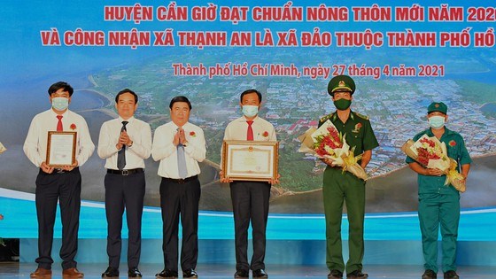 Đồng ch&iacute; Nguyễn Th&agrave;nh Phong v&agrave; Trần Lưu Quang trao quyết định của Thủ tướng Ch&iacute;nh phủ c&ocirc;ng nhận x&atilde; Thạnh An (huyện Cần Giờ) l&agrave; x&atilde; đảo thuộc TPHCM. Ảnh: VIỆT DŨNG