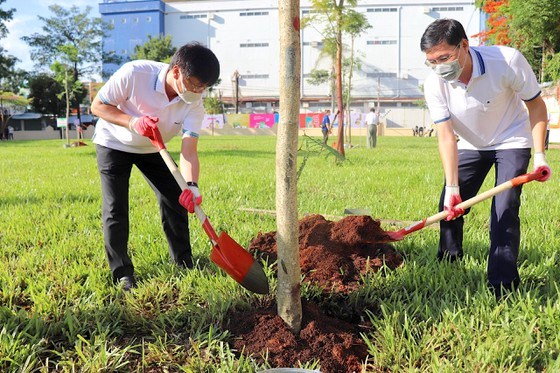 Chủ tịch UBND quận B&igrave;nh T&acirc;n (b&ecirc;n tr&aacute;i) tham gia trồng c&acirc;y