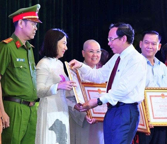 B&iacute; thư Th&agrave;nh ủy TPHCM Nguyễn Văn N&ecirc;n tặng bằng khen cho c&aacute;c điển h&igrave;nh xuất sắc tại buổi lễ. Ảnh: VIỆT DŨNG