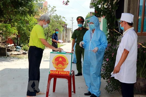 Cử tri khu vực cầu Tống, thuộc địa b&agrave;n x&oacute;m Hậu v&agrave; x&oacute;m Nh&acirc;n Trạch, x&atilde; Y&ecirc;n Thắng, huyện &Yacute; Y&ecirc;n (nơi đang được phong tỏa để ph&ograve;ng dịch), thực hiện việc bỏ phiếu bầu cử th&ocirc;ng qua h&ograve;m phiếu lưu động. (Ảnh: Văn Đạt/TTXVN)