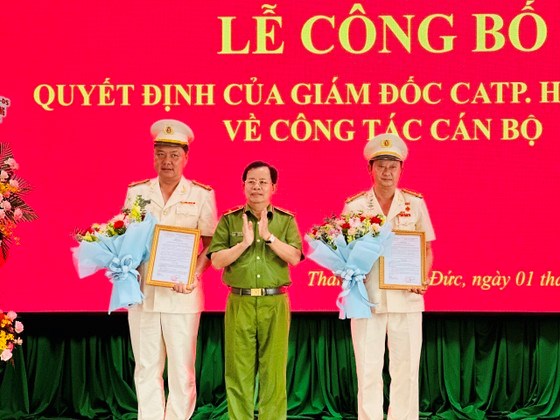 Thiếu tướng Trần Đức T&agrave;i, Ph&oacute; Gi&aacute;m đốc C&ocirc;ng an TPHCM trao quyết định cho 2 đồng ch&iacute;. Ảnh: CH&Iacute; THẠCH
