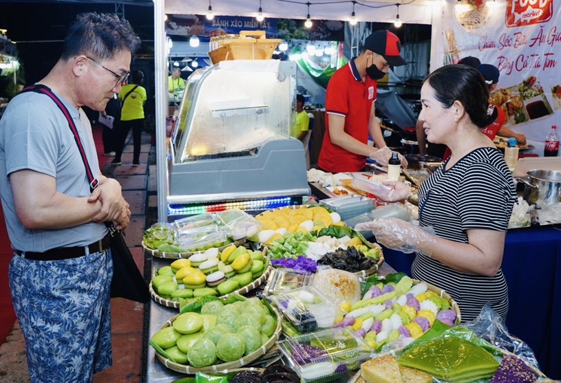 &Ocirc;ng Hishiro (du kh&aacute;ch Nhật) đang chọn những loại b&aacute;nh d&acirc;n gian của Việt Nam để thưởng thức - Ảnh: THANH HIỆP &nbsp;