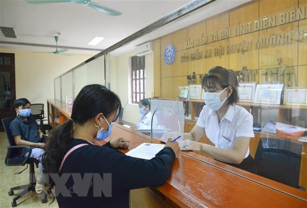 C&aacute;n bộ bảo hiểm x&atilde; hội hướng dẫn người d&acirc;n k&ecirc; khai đăng k&yacute; ứng dụng VssID. (Ảnh: Xu&acirc;n Tư/TTXVN)