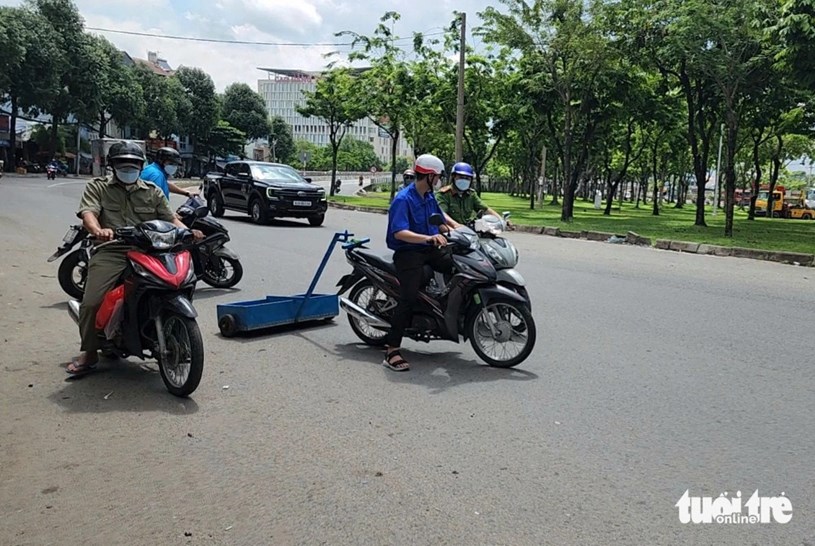 Đo&agrave;n thanh ni&ecirc;n phường Trung Mỹ T&acirc;y (quận 12) phối hợp với c&ocirc;ng an phường h&uacute;t đinh tr&ecirc;n quốc lộ 1, đoạn từ cầu vượt Quang Trung đến cầu vượt An Sương - Ảnh: NGỌC KHẢI &nbsp;