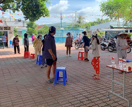 Người d&acirc;n x&atilde; T&acirc;n Thới Nh&igrave; xếp h&agrave;ng mua thực phẩm tại điểm b&aacute;n h&agrave;ng lưu động tại x&atilde;. Ảnh: TRẦN VĂN