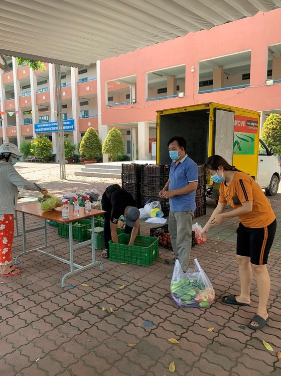 Người d&acirc;n mua thực phẩm tại "chợ lưu động" tổ chức ở x&atilde; T&acirc;n Thới Nh&igrave;, huyện H&oacute;c M&ocirc;n. Ảnh: TRẦN VĂN