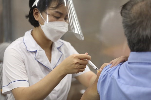 Nh&acirc;n vi&ecirc;n y tế ti&ecirc;m vaccine ph&ograve;ng COVID-19 cho người d&acirc;n. (Ảnh: Minh Quyết/TTXVN)