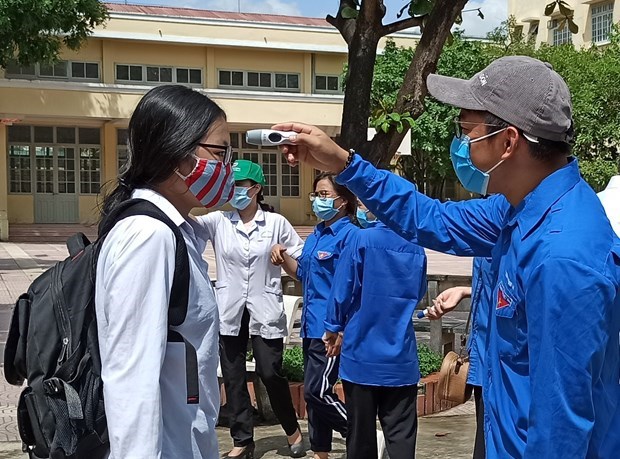 Th&iacute; sinh được đo th&acirc;n nhiệt trước khi v&agrave;o điểm thi tại Trường Trung học phổ th&ocirc;ng Ng&ocirc; Th&igrave; Nhậm. (Ảnh: Phạm Mai/Vietnam+)