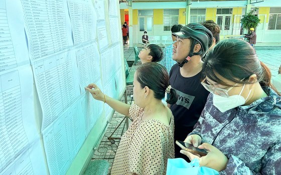 Phụ huynh xem danh s&aacute;ch học sinh lớp 6 năm học 2023-2024 tại Trường THCS Phan Đăng Lưu, quận 8, TPHCM. Ảnh: CAO THĂNG