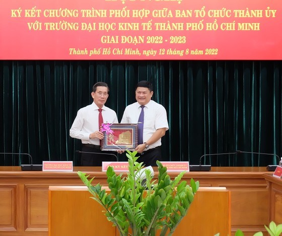 GS.TS Sử Đình Thành, Hiệu trưởng Trường ĐH Kinh tế TPHCM tặng quà lưu niệm cho Ban Tổ chức Thành ủy TPHCM. Ảnh: THU HƯỜNG