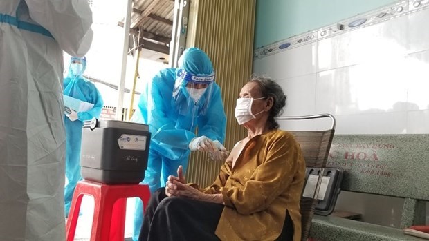 Lực lượng y tế tại Th&agrave;nh phố Hồ Ch&iacute; Minh đi từng ng&otilde;, g&otilde; từng nh&agrave; ti&ecirc;m vaccine COVID-19 cho người cao tuổi. (Ảnh: PV/Vietnam+)
