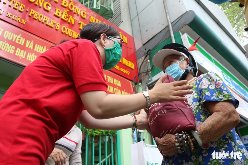 B&agrave; Ngọc Mai (85 tuổi) đi xe &ocirc;m đến nhận gạo ở P.Bến Th&agrave;nh, b&agrave; sống một m&igrave;nh n&ecirc;n lượng gạo n&agrave;y đủ cho b&agrave; ăn một tuần - Ảnh: HO&Agrave;NG AN