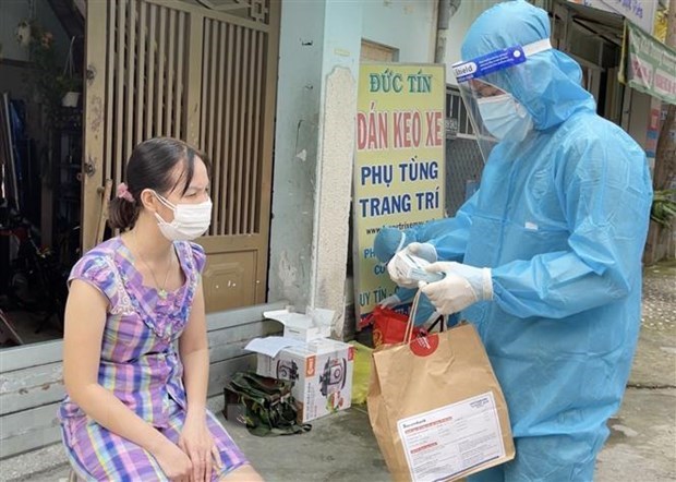 Nhân viên y tế trạm y tế lưu động phường 25, quận Bình Thạnh cấp phát túi thuốc cho F0 điều trị tại nhà. (Ảnh: Đinh Hằng/TTXVN)