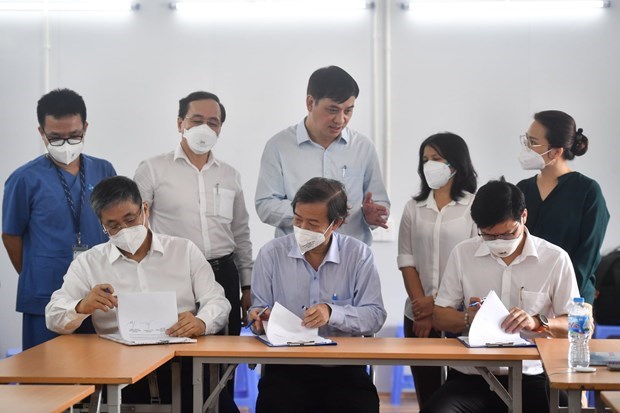 Các đại diện ký kết bàn giao Trung tâm Hồi sức Tích cực COVID-19. (Ảnh: PV/Vietnam+)