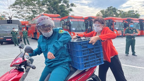 Hành lý, đồ đạc buôn bán trái cây của bà Lê Thị Diệu được chiến sĩ dân quân chở vào bến xe. Ảnh: VĂN MINH