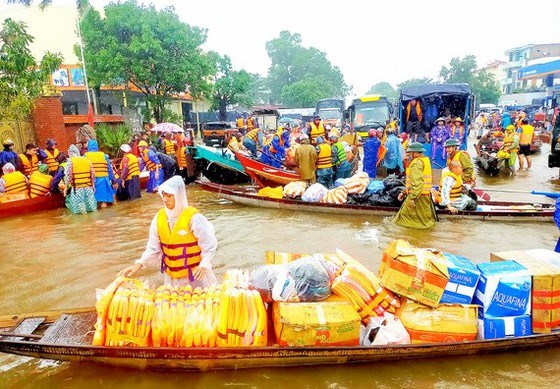Người d&acirc;n đổ về rốn lũ huyện Lệ Thủy, tỉnh Quảng B&igrave;nh để cứu trợ đồng b&agrave;o bị ngập lụt trong đợt mưa lũ tuần trước. Ảnh: SGGPO