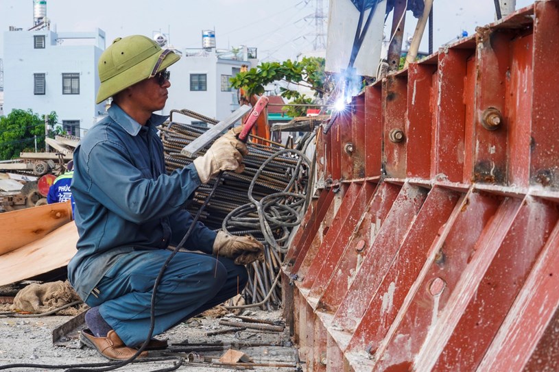 Tr&ecirc;n c&ocirc;ng trường, h&agrave;ng chục c&ocirc;ng nh&acirc;n c&ugrave;ng thiết bị m&aacute;y m&oacute;c đang khẩn trương ho&agrave;n thiện những hạng mục c&ograve;n lại của cầu.