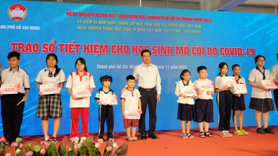 Ph&oacute; Chủ tịch UBND TPHCM Nguyễn Văn Dũng trao Sổ tiết kiệm cho trẻ mồ c&ocirc;i do Covid-19. Ảnh: LONG HỒ &nbsp;