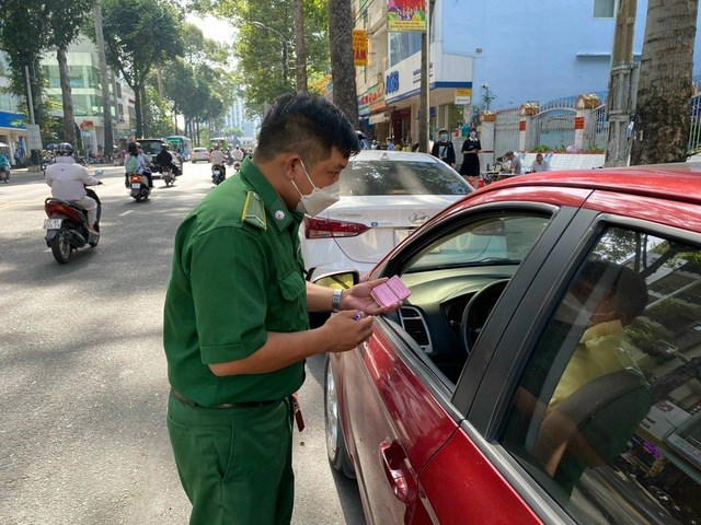 Nh&acirc;n vi&ecirc;n thu ph&iacute; hướng dẫn t&agrave;i xế - Ảnh: THU HỒNG