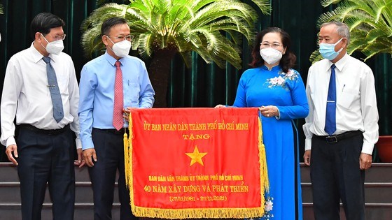 Chủ tịch HĐNDTPHCM Nguyễn Thị Lệ tặng cờ truyền thống của UBND TPHCM cho Ban D&acirc;n Vận Th&agrave;nh ủy. Ảnh: VIỆT DŨNG