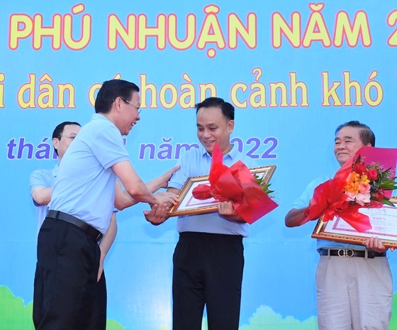 Chủ tịch UBND TPHCM Phan Văn M&atilde;i tặng bằng khen cho c&aacute;c c&aacute; nh&acirc;n tại cuộc đi bộ. Ảnh: VIỆT DŨNG