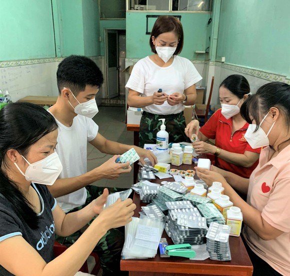 Y bác sĩ trạm y tế lưu động phường 5 (Gò Vấp) đến từ BV Quân y 175 chuẩn bị thuốc mang đến cho F0 điều trị tại nhà. Ảnh: TÂM HIỀN