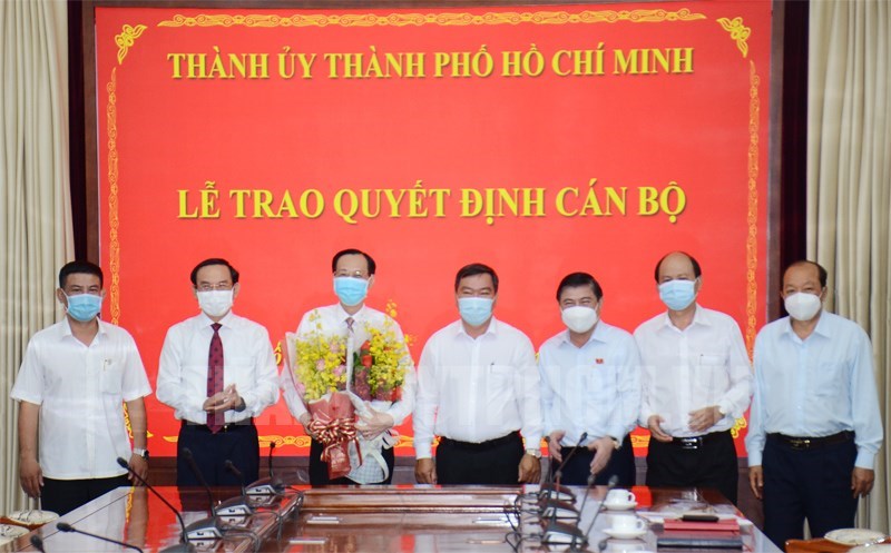 B&iacute; thư Th&agrave;nh ủy Nguyễn Văn N&ecirc;n c&ugrave;ng c&aacute;c đại biểu trao quyết định v&agrave; tặng hoa ch&uacute;c mừng đồng ch&iacute; L&ecirc; Thanh Li&ecirc;m.