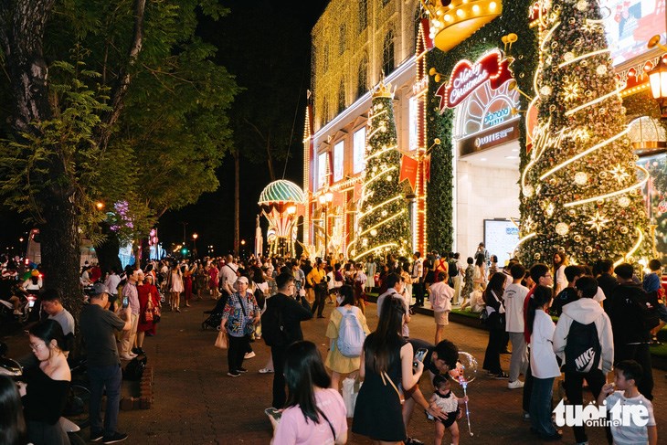 Người d&acirc;n tập trung đến trung t&acirc;m thương mại Diamond Plaza, quận 1 để h&ograve;a chung v&agrave;o kh&ocirc;ng kh&iacute; Gi&aacute;ng sinh tối 23-12 - Ảnh: THANH HIỆP