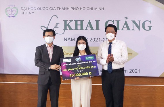 ThS Nguyễn Thanh Nguy&ecirc;n (phải) trao học bổng của Quỹ Ph&aacute;t triển ĐHQG-HCM cho thủ khoa tuyển sinh của Khoa Y ĐHQG-HCM