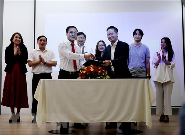Đại diện EVN HCMC (bên trái) và  MoMo ký  kết hợp tác.  (Ảnh: Thành Chung/TTXVN)