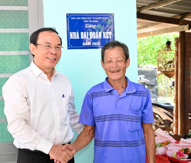 B&iacute; thư Th&agrave;nh ủy TPHCM Nguyễn Văn N&ecirc;n ch&uacute;c mừng hộ gia đ&igrave;nh &ocirc;ng Nguyễn Văn Đực nhận nh&agrave; đại đo&agrave;n kết. Ảnh: VĂN MINH