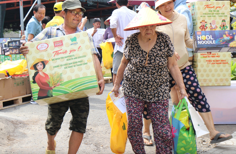 B&agrave; con x&oacute;m ve chai đỡ đần nhau mang qu&agrave; tết về nh&agrave;. Người trẻ th&igrave; gi&uacute;p người gi&agrave; x&aacute;ch, khi&ecirc;ng v&aacute;c c&aacute;c đồ nặng v&agrave;o nh&agrave;