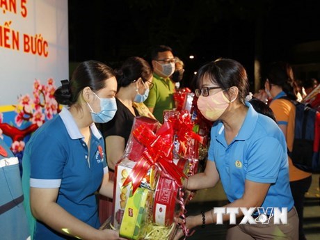 L&atilde;nh đạo Li&ecirc;n đo&agrave;n Lao động th&agrave;nh phố trao tặng qu&agrave; v&agrave; tiền Tết cho người lao động c&oacute; ho&agrave;n cảnh kh&oacute; khăn ở quận 5 trong Chương tr&igrave;nh "Tết Sum vầy." (Ảnh: Thanh Vũ/TTXVN)