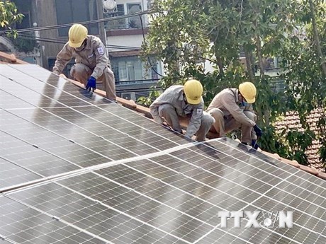 Đo&agrave;n vi&ecirc;n thanh ni&ecirc;n Tổng C&ocirc;ng ty Điện lực Th&agrave;nh phố Hồ Ch&iacute; Minh lắp đặt hệ thống điện năng lượng mặt trời tại L&agrave;ng Thiếu ni&ecirc;n Thủ Đức. (Ảnh: Hồng Giang/TTXVN)