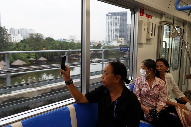 Người d&acirc;n lưu lại h&igrave;nh ảnh đ&ocirc; thị b&ecirc;n ngo&agrave;i khi trải nghiệm tuyến metro số 1. (Ảnh: Huyền Trinh/TTXVN)